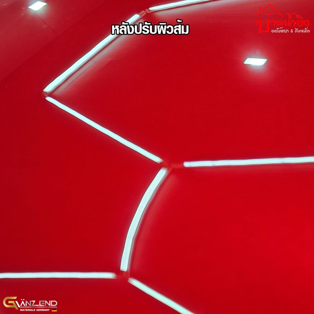 แผงสีแดงเดิมหลังขัดปรับผิวส้ม เงาสะท้อนไฟเพดานกลับมาเป็นเส้นขอบคมตรง มีข้อความ 'หลังปรับผิวส้ม' กำกับบนภาพ